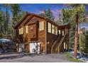 Inviting exterior view showcasing the home's wooden facade, garage, and staircase leading to the entrance at 6752 S Columbine Rd, Evergreen, CO 80439