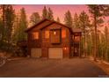 Inviting two-story home featuring a two-car garage and staircase to a cozy outdoor porch at 6752 S Columbine Rd, Evergreen, CO 80439
