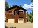Exterior shot of a two-car garage, with a wooden exterior and partial view of the roofline at 6752 S Columbine Rd, Evergreen, CO 80439