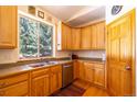 Kitchen featuring wooden cabinets, countertop, sink and a view of the outside through the window at 6752 S Columbine Rd, Evergreen, CO 80439