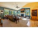 Bright living room with a fireplace and large windows overlooking trees, filling the space with natural light at 6752 S Columbine Rd, Evergreen, CO 80439
