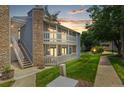 Charming two-story condo with stone accents, a balcony, stairs, and a well-maintained lawn at 8600 E Alameda Ave # 22-208, Denver, CO 80247