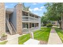 Charming two-story condo with stone accents, a balcony, stairs, and a well-maintained lawn at 8600 E Alameda Ave # 22-208, Denver, CO 80247