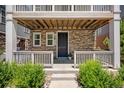 Inviting front porch with stone accents and manicured greenery at 12714 E Dickenson Ave, Aurora, CO 80014