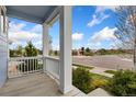 Inviting covered porch view showcasing the neighborhood with lush landscaping and clear blue skies at 713 San Juan Dr, Lafayette, CO 80026