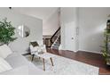 Cozy living room showcasing hardwood floors, neutral decor, staircase and vaulted ceiling at 6342 Marshall St, Arvada, CO 80003