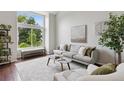 Comfortable living room featuring a large window and view of mature landscaping at 6342 Marshall St, Arvada, CO 80003