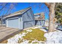 Exterior view of a home with blue siding, attached garage, and well-kept lawn at 10626 W Park Mtn, Littleton, CO 80127