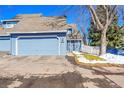 Home exterior showcasing an attached garage, blue siding, and a well-maintained yard at 10626 W Park Mtn, Littleton, CO 80127