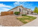 Landscaped front yard with decorative rock and green grass leading up to a well maintained home at 581 Park Blvd, Brighton, CO 80603