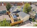 Aerial view of a home with a lovely backyard patio, a detached garage, and fencing at 8865 E 28Th Ave, Denver, CO 80238