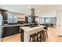 Modern kitchen with large island, stainless steel appliances, dark cabinetry, and sleek countertops at 5020 E 120Th Pl, Thornton, CO 80241