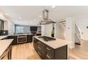 Open-concept kitchen with large island, stainless steel range hood, and abundant drawer space at 5020 E 120Th Pl, Thornton, CO 80241