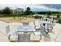 Community playground with multiple picnic tables, climbing frame, and distant mountain views at 14673 E Belleview Dr, Aurora, CO 80015