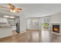Open-concept living area with fireplace, new flooring, and bright, white kitchen at 12625 E Pacific Cir # E, Aurora, CO 80014
