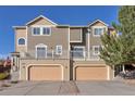 Exterior angle of a two-story townhouse highlighting the facade and attached garages at 2673 Live Oak Ct, Castle Rock, CO 80104