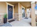 Inviting front porch featuring a stylish blue door, brick accents and neutral siding at 376 Dallas St, Denver, CO 80230