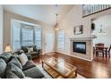 Bright living room with hardwood floors, a fireplace, and large bay windows at 1104 Rumbling Sky Pl, Castle Rock, CO 80108