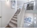 Modern staircase with white railings and carpeted steps leading to the upper level at 16130 E 111Th Dr, Commerce City, CO 80022