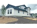 Side view of a modern white house with dark trim and gravel landscaping at 39836 Floyd St, Elizabeth, CO 80107