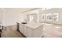 Kitchen island featuring a sink and dishwasher, complemented by an open-concept living area at 39836 Floyd St, Elizabeth, CO 80107