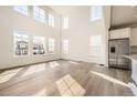 Bright living room with large windows, hardwood floors, and stainless steel refrigerator at 39836 Floyd St, Elizabeth, CO 80107