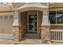 Inviting front entrance with stone pillars and trim, leading to a beautifully designed front door at 22665 E Calhoun Pl, Aurora, CO 80016