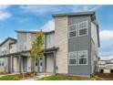 Townhome exterior featuring gray siding, stone accents, and a landscaped yard at 20530 E 58Th Ave, Aurora, CO 80019