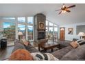 Bright living room featuring a stone fireplace, vaulted ceilings, and expansive windows with scenic views at 28364 Tresine Dr, Evergreen, CO 80439