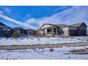 Two-story house with snow-covered yard and neighborhood view at 7766 Fraser River Cir, Littleton, CO 80125