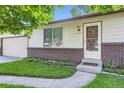 Close up of a charming home featuring a well-manicured front yard and lovely landscaping at 11617 W 71St Dr, Arvada, CO 80004