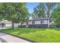 Inviting home with lush green lawn, mature tree, and neatly maintained landscaping at 11617 W 71St Dr, Arvada, CO 80004