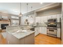 Bright kitchen featuring an island, stainless steel appliances, tile backsplash and modern pendant lighting at 880 E 16Th Ave # D, Denver, CO 80218