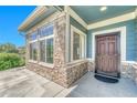 Inviting front porch featuring stone accents, a secure front door, and ample natural light at 12444 Madison Way, Thornton, CO 80241