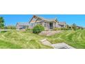 Well-maintained front yard featuring lush greenery, decorative landscaping, and a charming exterior at 12444 Madison Way, Thornton, CO 80241