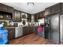 Galley kitchen with wood floor, stainless steel appliances, stylish cabinets, and granite counters at 8820 Poze Blvd, Thornton, CO 80229
