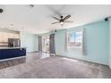 Bright living room featuring a ceiling fan, carpet, and access to the patio at 10506 Akron St, Commerce City, CO 80640