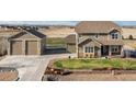 Charming two-story home with a landscaped front yard, stone accents, and a detached two-car garage at 11343 E 163Rd Ct, Brighton, CO 80602