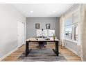 Comfortable home office with gray accent wall, wood floors, a modern desk, and bright natural light at 11343 E 163Rd Ct, Brighton, CO 80602