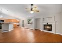 Open-concept living room with fireplace, ceiling fan, and natural light from the sliding glass doors at 5214 S Tibet St, Aurora, CO 80015