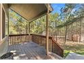 The spacious porch features wooden railings and supports with forest views of the surrounding yard at 34103 Forest Park Dr, Elizabeth, CO 80107
