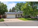 A suburban home featuring solar panels, a two-car garage, and a well-manicured front lawn at 9575 Garland Ct, Westminster, CO 80021