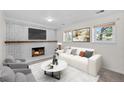 Comfortable living room featuring a fireplace, a large sofa, and bright windows at 9575 Garland Ct, Westminster, CO 80021