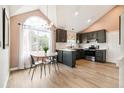 Eat-in kitchen with stainless appliances, wood floors, gray cabinets, and large window at 3612 Rosewalk Cir, Highlands Ranch, CO 80129