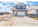 Charming two-story home with blue siding, stone accents, a covered porch, and a two-car garage at 18120 Dandy Brush Ln, Parker, CO 80134