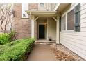 Front entry with covered porch and walkway with a small garden at 12973 Grant E Cir # A, Thornton, CO 80241