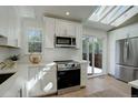 Bright kitchen with stainless steel appliances, white cabinets, and skylights at 291 W Sycamore Ln, Louisville, CO 80027