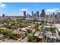 Scenic view showcasing the Denver skyline, lush green trees and neighborhood architecture at 2524 Champa St # 1, Denver, CO 80205