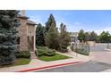 Well-manicured landscaping leads to the Pinnacle Ranch community entrance with lush trees at 9944 E Carolina Cir # 201, Aurora, CO 80247