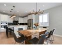 Eat in kitchen features modern light fixture, black barstools, and stainless steel appliances at 5271 Routt Ct, Arvada, CO 80002